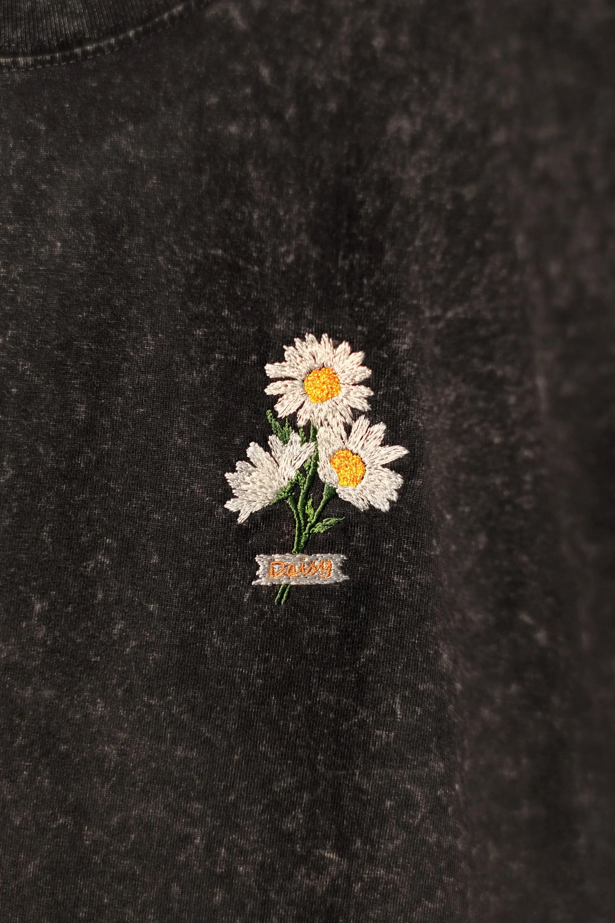 Black t-shirt embroidered with daisy flowers. Oversize shirt form. Streetwear style