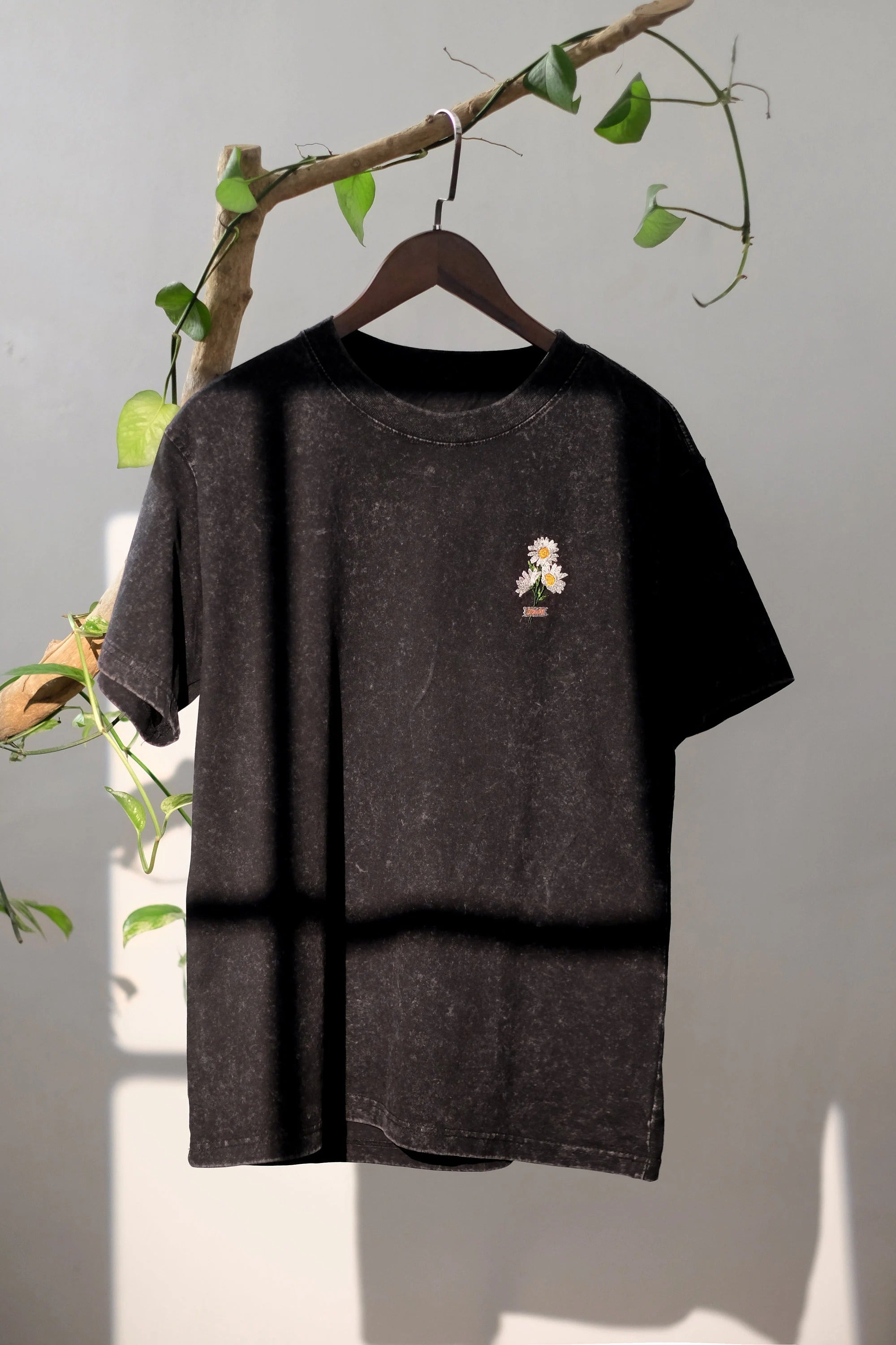 Black t-shirt embroidered with daisy flowers. Oversize shirt form. Streetwear style